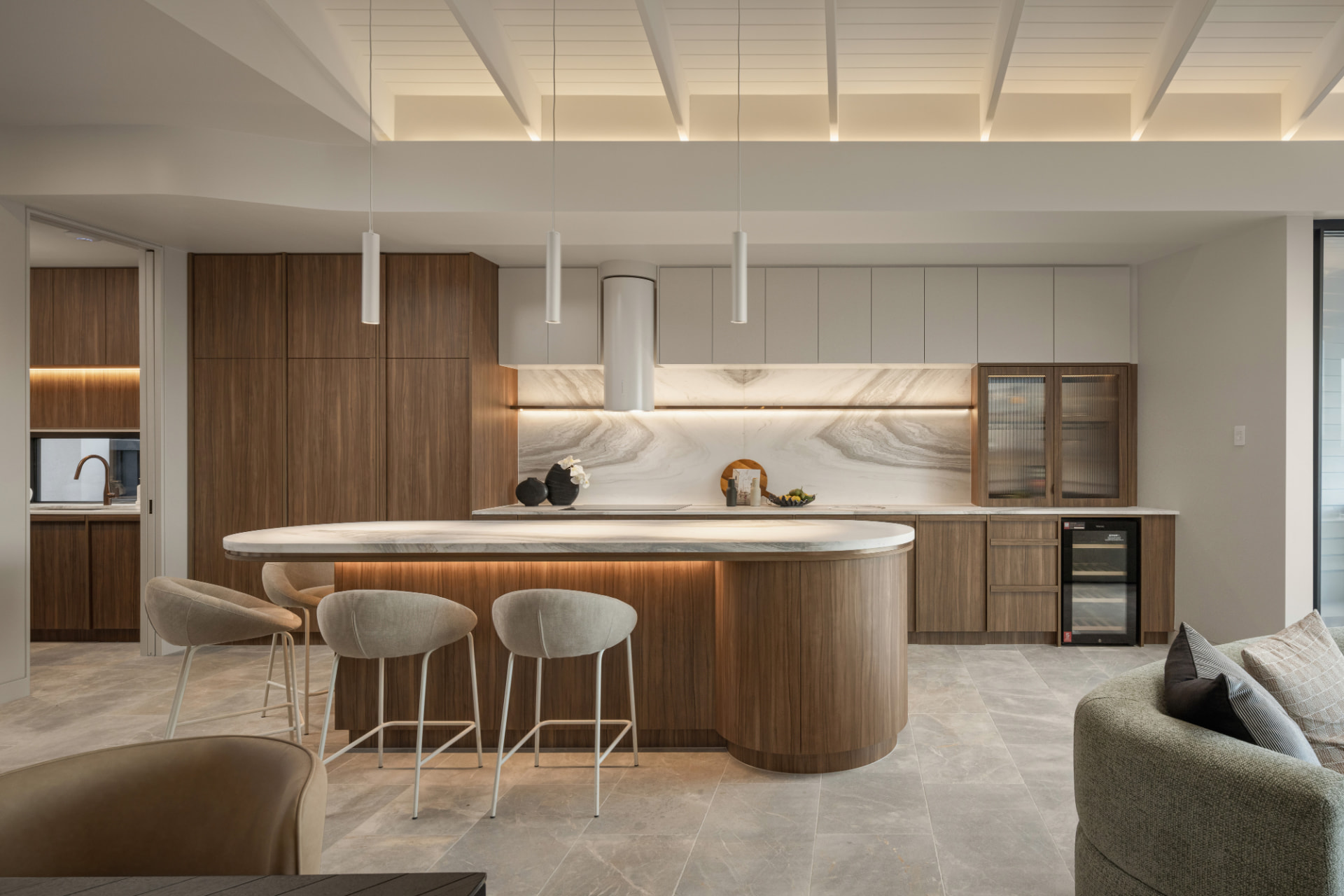 Curved stone island and Yarra Walnut joinery in the designer kitchen