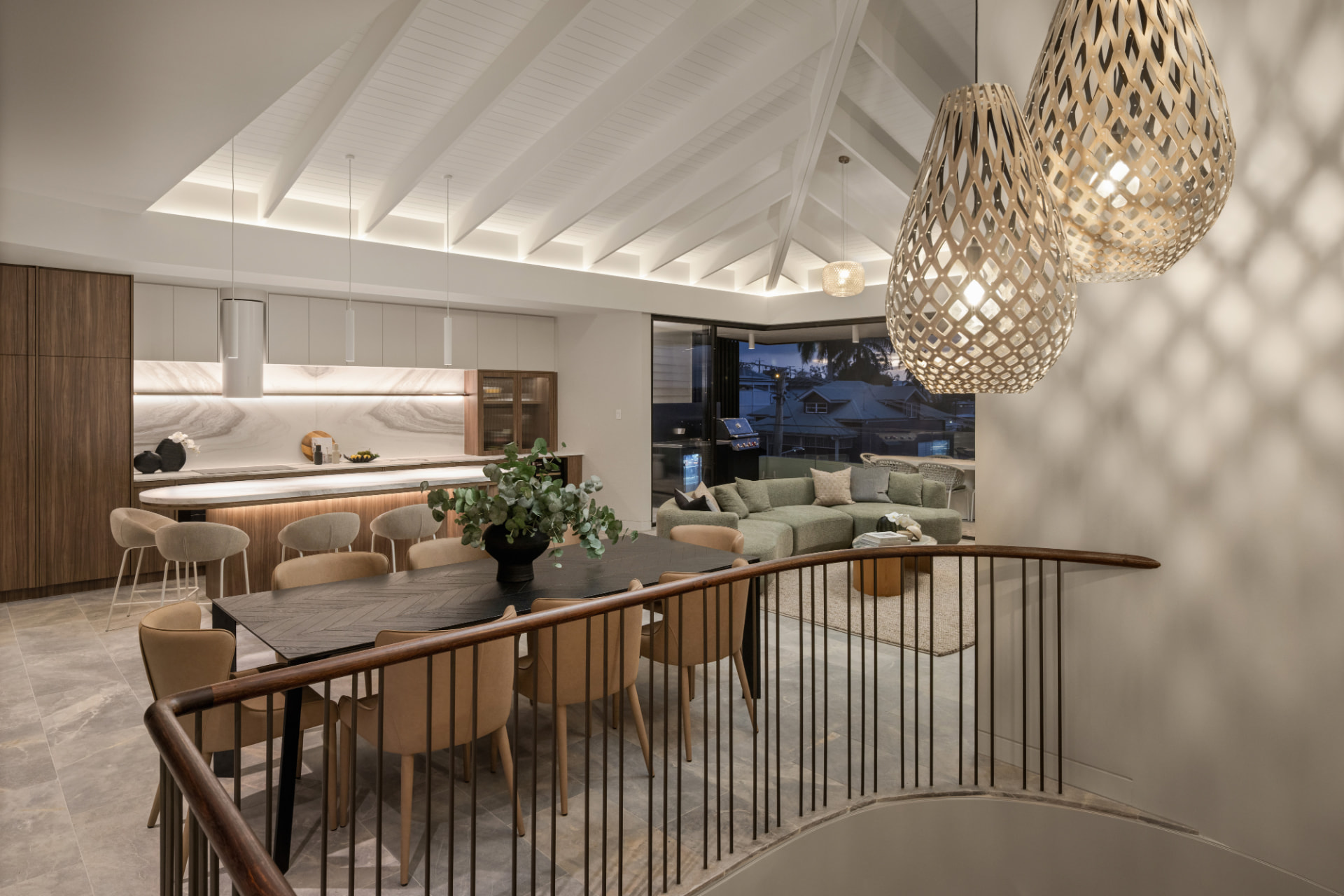 Vaulted dining and living area with woven pendants at dusk